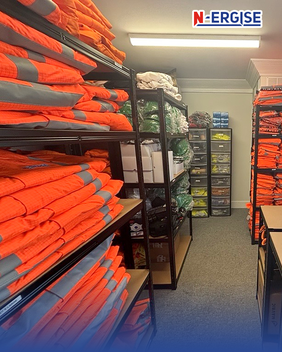 N-ERGISE PPE store with shelves of folded orange coveralls, workwear and labelled storage drawers
